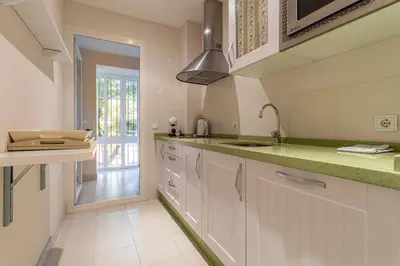 a kitchen with white cabinets and green counter tops at Allo Apartments Santo Domingo Parking 2 Habitaciones in Jerez de la Frontera