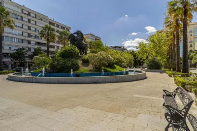 a statue of a lion in a park with benches at Allo Apartments Santo Domingo Parking 2 Habitaciones in Jerez de la Frontera