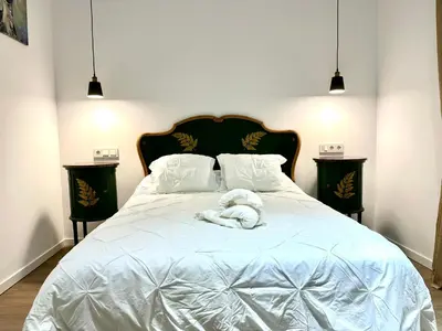 a white dog laying on top of a bed at Apartamento Nebro Luna, En el Corazón de Cádiz in Cádiz
