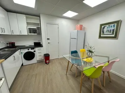 a kitchen with a glass table and chairs in a room at Apartamento Nebro Luna, En el Corazón de Cádiz in Cádiz