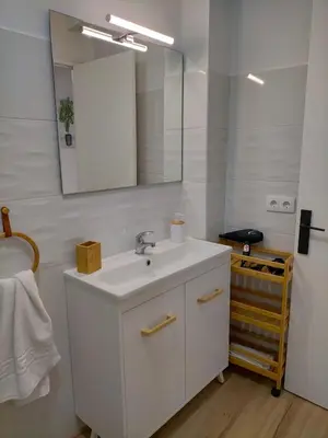 a bathroom with a white sink and a mirror at Apartamento Lola Home in Sanlúcar de Barrameda