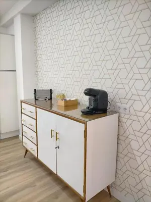 a room with a desk and a wall with a geometric wallpaper at Apartamento Lola Home in Sanlúcar de Barrameda