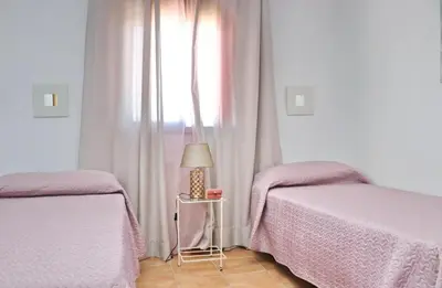 a bedroom with two beds and a window at Chalet Arroyo in Conil de la Frontera