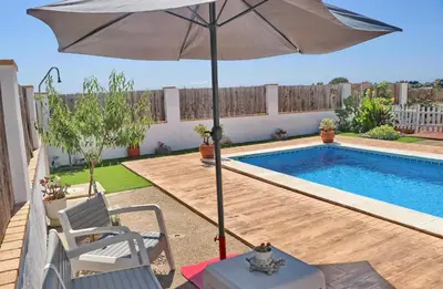 a patio with an umbrella and a swimming pool at Chalet Arroyo in Conil de la Frontera