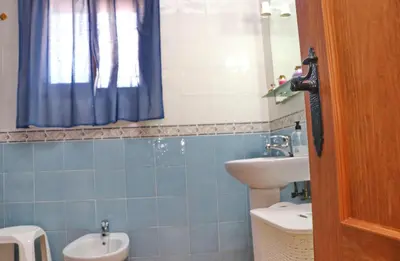a bathroom with a sink and a toilet and a mirror at Chalet Arroyo in Conil de la Frontera