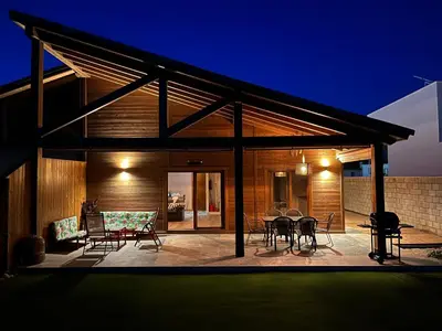 a patio with a table and chairs on it at night at Villas Magnolia y Brezo in Chiclana de la Frontera