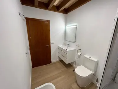 a bathroom with a toilet and a sink and a mirror at Villas Magnolia y Brezo in Chiclana de la Frontera