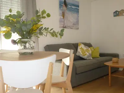 a living room with a table and a couch at Ático con terraza La Venencia in Sanlúcar de Barrameda