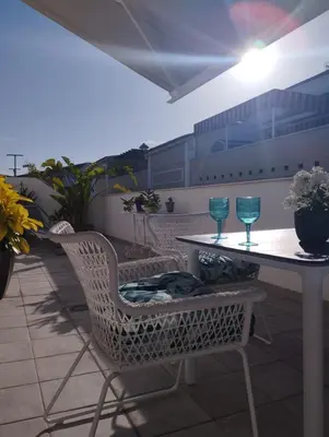 a table and chairs with wine glasses on a patio at Ático con terraza La Venencia in Sanlúcar de Barrameda