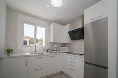 a white kitchen with a sink and a window at Ático con terraza La Venencia in Sanlúcar de Barrameda