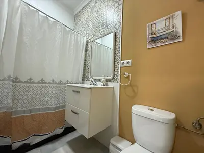 a bathroom with a toilet and a sink and a mirror at Salmedina in Sanlúcar de Barrameda