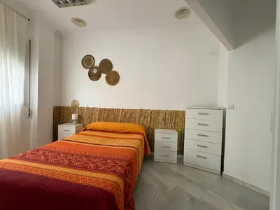 a bedroom with a bed and a dresser at Salmedina in Sanlúcar de Barrameda