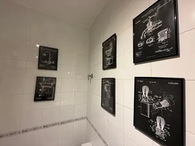 a bathroom with black and white pictures on the wall at Salmedina in Sanlúcar de Barrameda