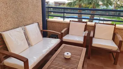 two chairs and a table on a balcony with a view at Aires de Doñana. Piscina y Playa. Parking gratis. in Sanlúcar de Barrameda