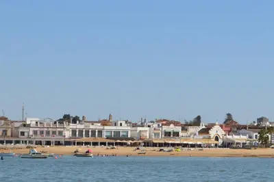 a view of a beach with boats in the water at Aires de Doñana. Piscina y Playa. Parking gratis. in Sanlúcar de Barrameda
