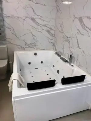 a white bath tub in a bathroom with marble walls at LOFT VILLALUCIA in Conil de la Frontera