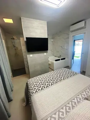 a bedroom with a bed and a tv on a wall at LOFT VILLALUCIA in Conil de la Frontera