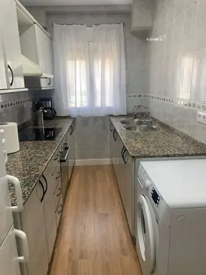 a kitchen with a sink and a washing machine at Ribeira en Playa Victoria Grupo AC Gestion in Cádiz