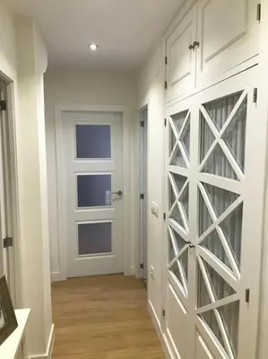 a hallway with a white door and a room with wooden floors at Ribeira en Playa Victoria Grupo AC Gestion in Cádiz