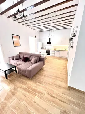 a living room with a couch and a kitchen at Tía Norica - Centro Cádiz in Cádiz