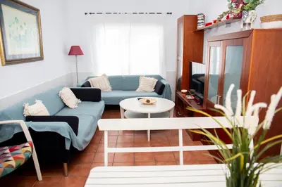 a living room with a blue couch and a table at Poniente in Roche