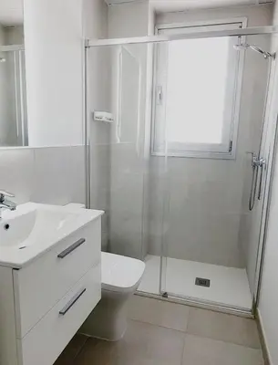 a bathroom with a shower and a toilet and a sink at ÁTICOS ROTA Punta Candor in Rota