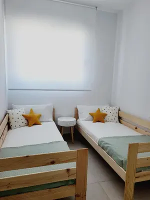 two beds sitting next to each other in a room at ÁTICOS ROTA Punta Candor in Rota