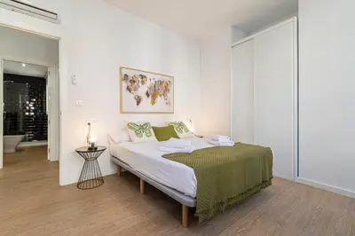 a white bedroom with a bed with a green blanket at Allo Apartments Santa Maria II Centro 2 Habitaciones in Jerez de la Frontera