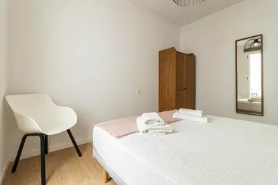 a bedroom with a white bed and a white chair at Allo Apartments Santa Maria II Centro 2 Habitaciones in Jerez de la Frontera