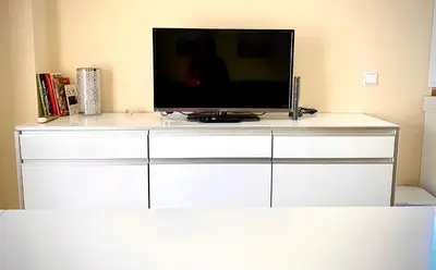 a tv sitting on top of a white dresser at MyChoice Meninas in Rota