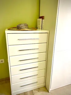 a white dresser in a room with a green wall at MyChoice Meninas in Rota