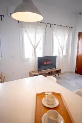 a living room with a table with two cups on it at Apartamento con terraza privada en el centro del Puerto de Santa María in El Puerto de Santa María