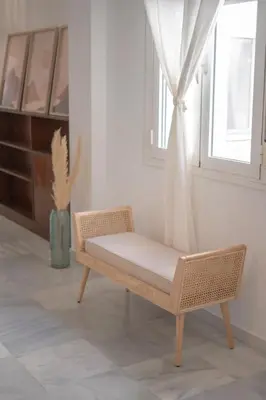 a wicker chair in a room with a window at Apartamento con terraza privada en el centro del Puerto de Santa María in El Puerto de Santa María