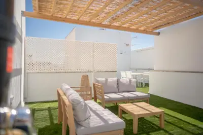 a patio with two chairs and a couch and a table at Apartamento con terraza privada en el centro del Puerto de Santa María in El Puerto de Santa María