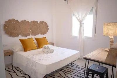 a bedroom with a bed with yellow pillows and a window at Apartamento con terraza privada en el centro del Puerto de Santa María in El Puerto de Santa María