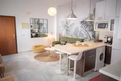 a kitchen and living room with a table in a kitchen at Apartamento con terraza privada en el centro del Puerto de Santa María in El Puerto de Santa María