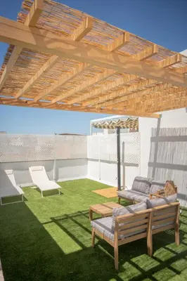 a patio with two chairs and a table and an umbrella at Apartamento con terraza privada en el centro del Puerto de Santa María in El Puerto de Santa María