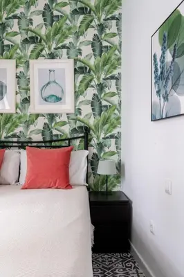 a bedroom with a bed with a plant wallpaper at Casa Carmen - Super céntrico y cómodo in Jerez de la Frontera