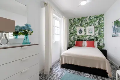 a bedroom with a bed with red pillows at Casa Carmen - Super céntrico y cómodo in Jerez de la Frontera