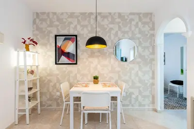 a dining room with a white table and chairs at Casa Carmen - Super céntrico y cómodo in Jerez de la Frontera