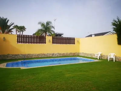 a swimming pool in a yard with two chairs at Casa Ye Ye in Novo Sancti Petri
