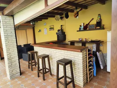 a bar with two stools and a counter in a room at Casa Ye Ye in Novo Sancti Petri