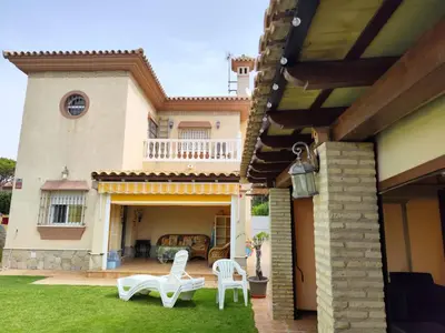 a patio with white chairs and a house at Casa Ye Ye in Novo Sancti Petri