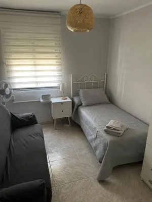 a bedroom with two beds and a table and a window at Apartamento Sotest in Jerez de la Frontera
