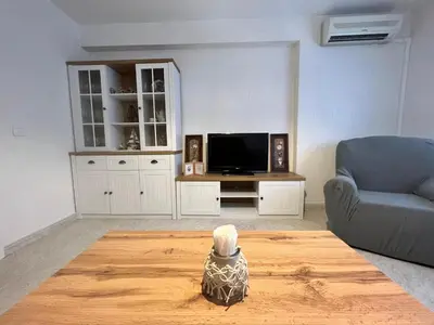 a living room with a tv and a chair and a table at Apartamento Sotest in Jerez de la Frontera