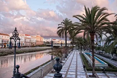 a sandy beach with people in the water and the ocean at Fancy apartment in a Historic house, Chiclana City Center by C. Dreams in Chiclana de la Frontera