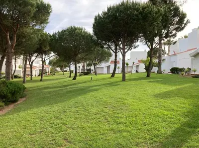 a park with trees and grass and buildings at bamboo & golf house in Campano