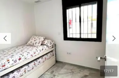 a small bedroom with a bed and a window at Ático céntrico con terraza privada y plaza de garaje in Sanlúcar de Barrameda