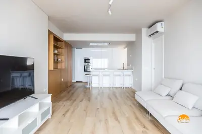 a living room with a white couch and a kitchen at Malibu by Cadiz Time in Cádiz