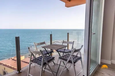 a table and chairs on a balcony with the ocean at Malibu by Cadiz Time in Cádiz